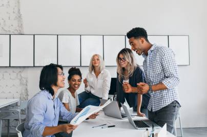 Multicultural business team collaborating on documents during a corporate meeting, showcasing teamwork and workplace diversity.