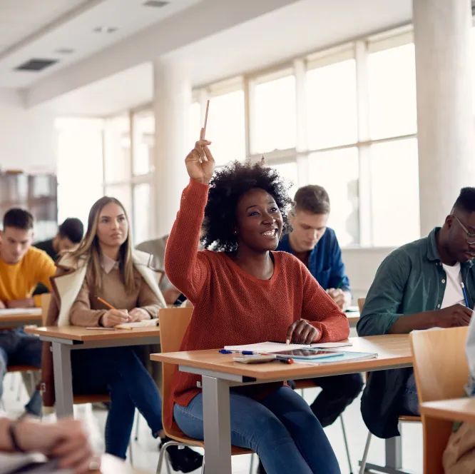 Élève levant la main dans une classe attentive